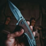 a hand holding an open tactical folding knife blade in full view