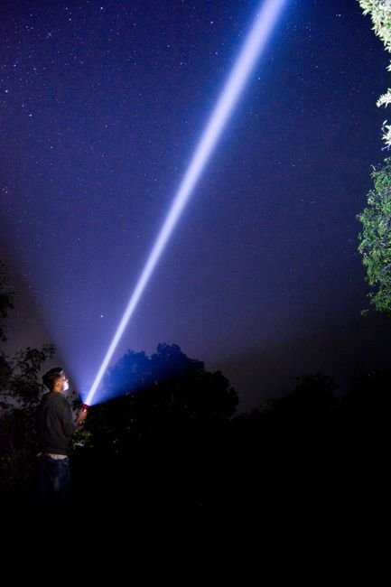 bright flashlight beam projected into the night sky showing long range throw