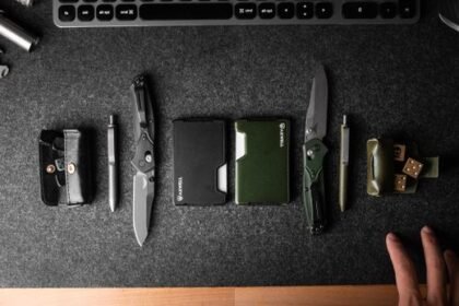 Everyday carry tools laid out on a dark desk beside a keyboard