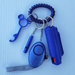 pepper spray canister on a keychain alongside a personal safety whistle