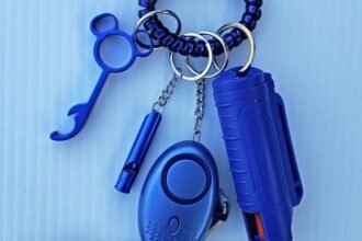 pepper spray canister on a keychain alongside a personal safety whistle
