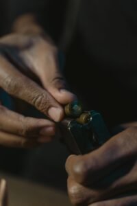 hands loading cartridges into a pistol magazine after a range session