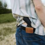 pistol carried in a waistband holster under an untucked shirt showing how clothing conceals printing