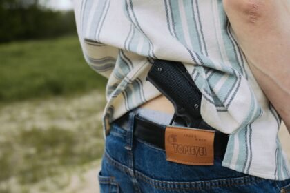Pistol carried in a waistband holster under an untucked shirt, showing how clothing conceals printing
