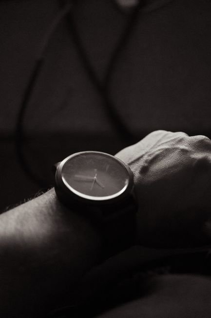 A monochrome close-up of a wristwatch worn on the wrist
