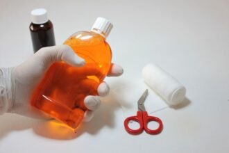 pexelsphoto5146537 edc deals hand holding an antiseptic bottle alongside first aid supplies for cleaning a wound
