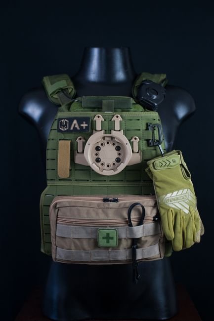 A military tactical vest with gloves displayed on a mannequin