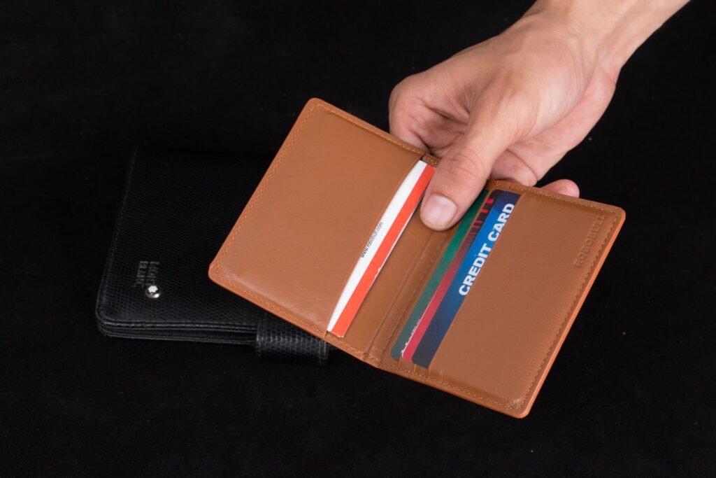 hand holding an open leather card holder with cards seated in its slots