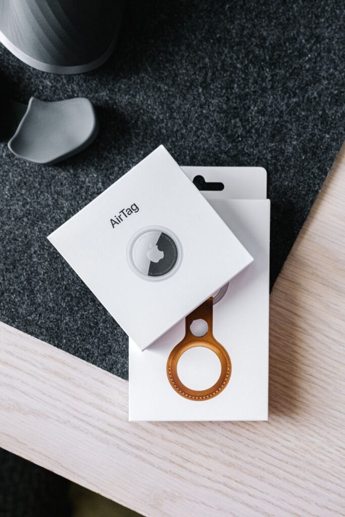 apple airtag and leather key ring packaging on a wooden surface