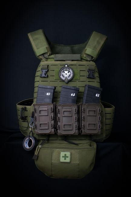 Close-up of a tactical vest with pouches and magazines on a black background