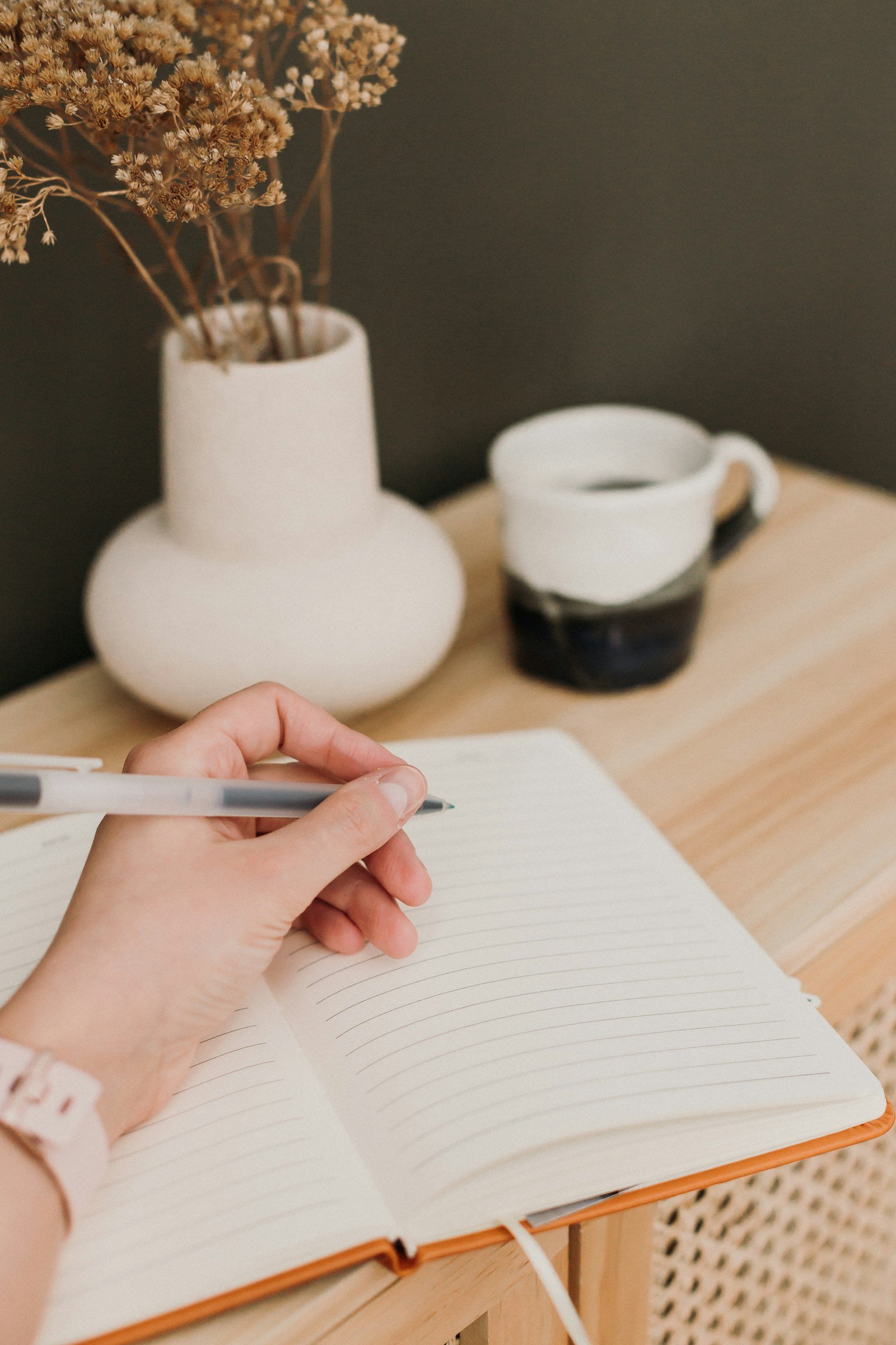 person writing a standing note in a small pocket notebook