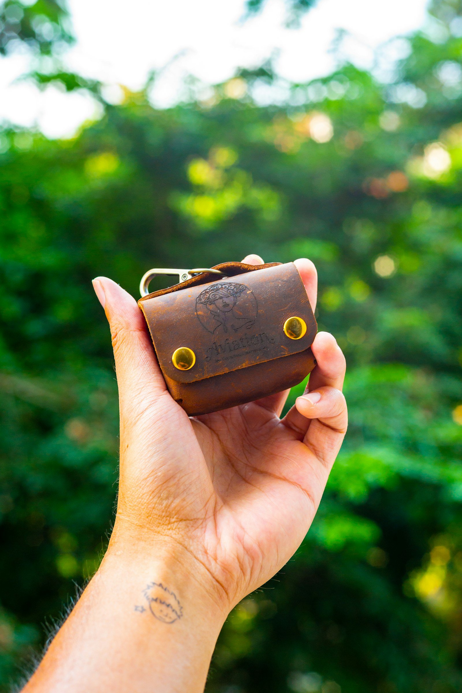hand holding a small leather key organizer pouch with a keychain