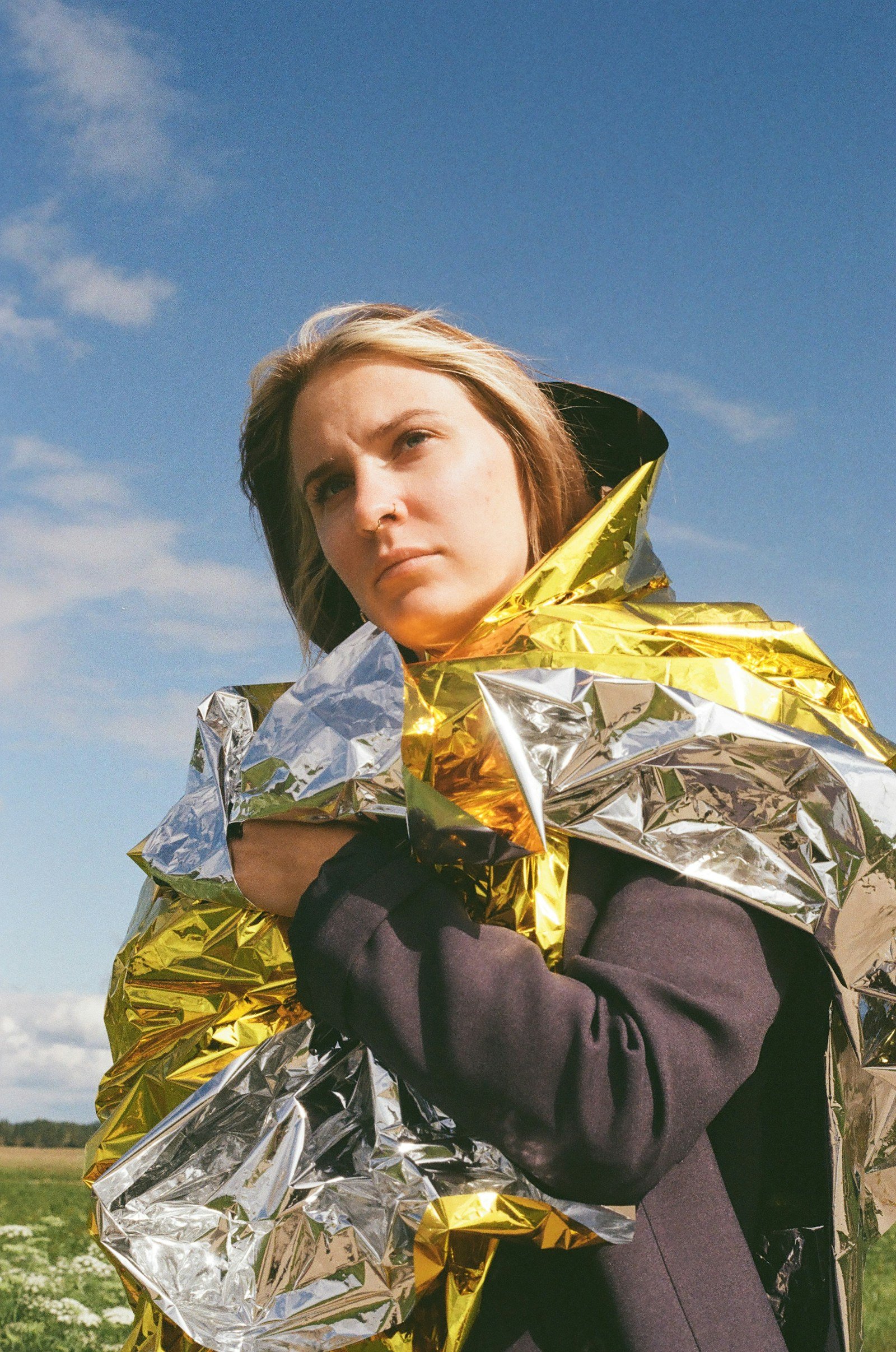 person wrapped in a gold and silver mylar emergency blanket