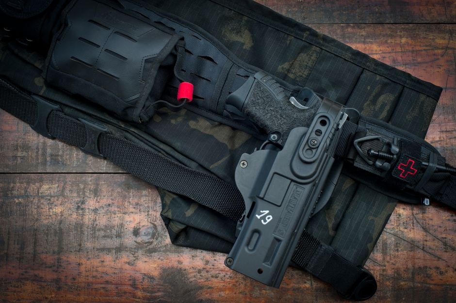 close up of a tactical gun belt holding a holstered handgun