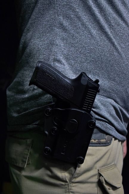 pexels12114190 edc deals pistol carried in a holster secured to a gun belt at the hip