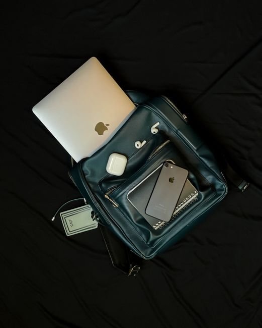 pexels12743405 edc deals top view of a backpack packed with a laptop smartphone and earphones for a first day at work