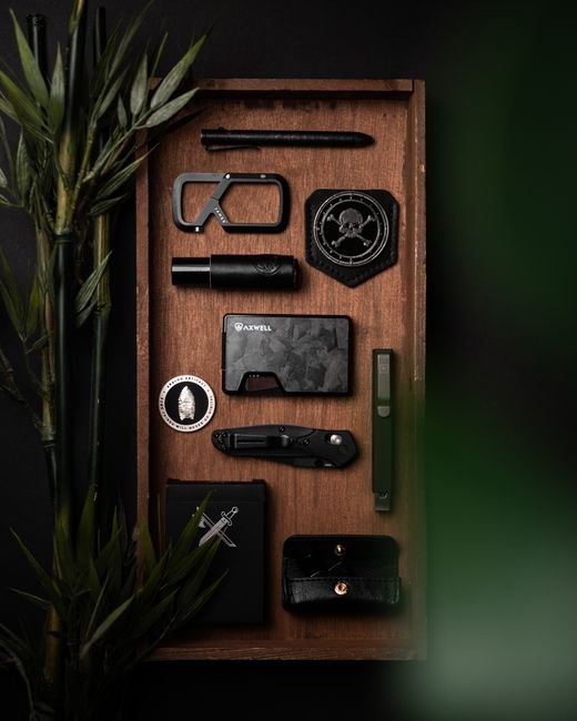 everyday carry items neatly arranged on a wooden tray