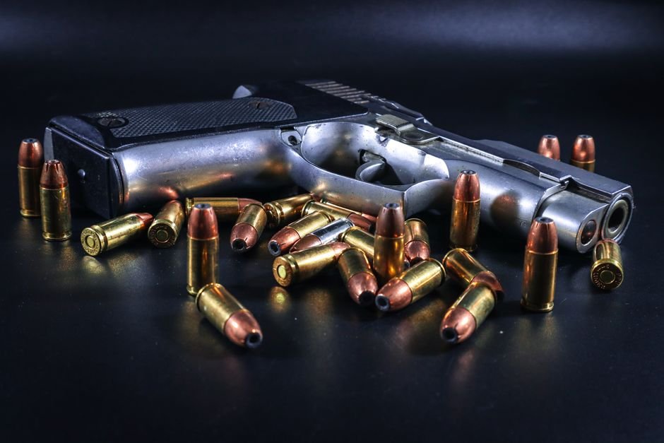 compact pistol surrounded by brass 380 cartridges