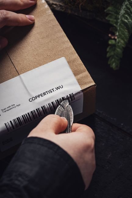 a small metal keychain pry tool being used to open a package