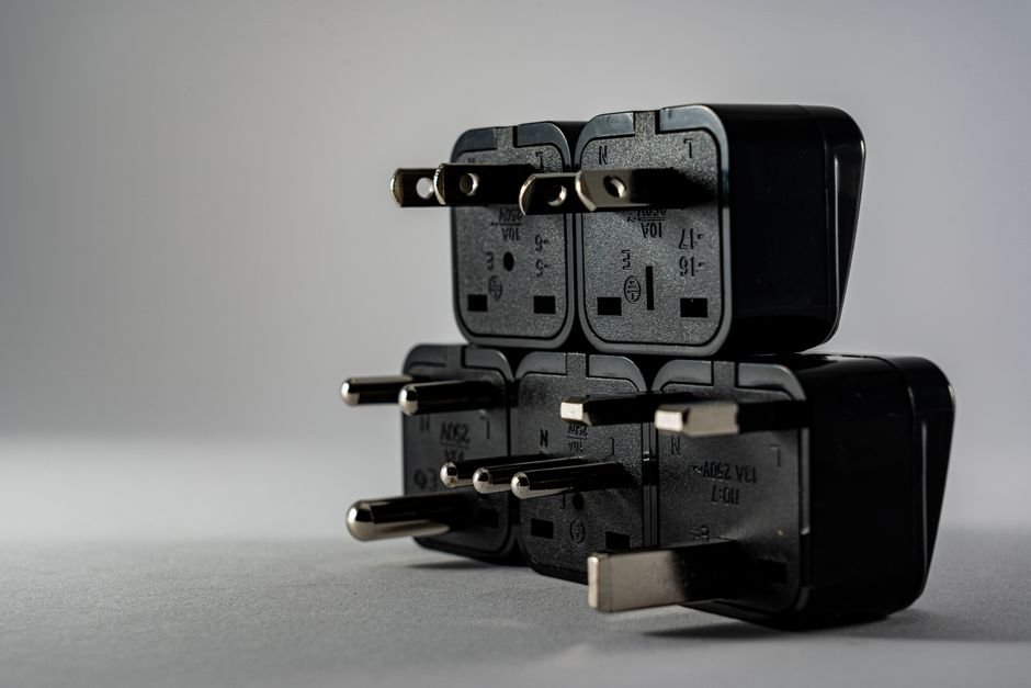 a stack of black universal travel plug adapters