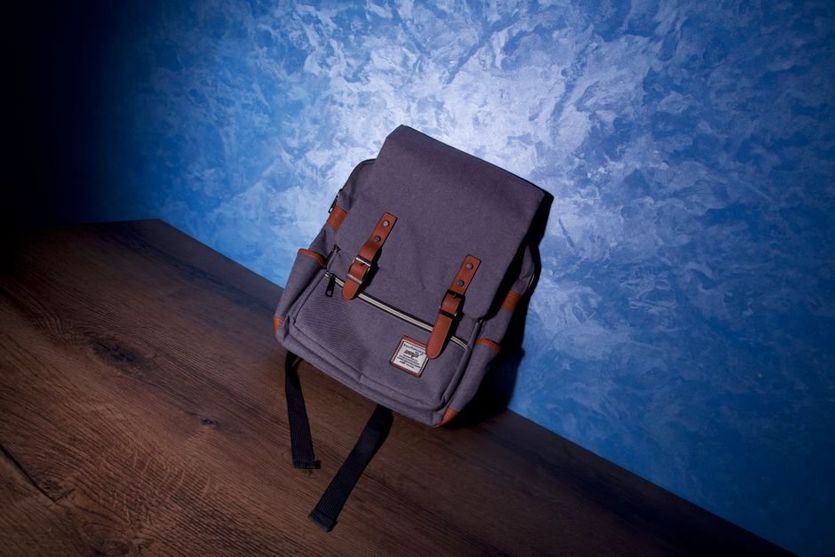 modern edc backpack with leather straps on a wooden surface