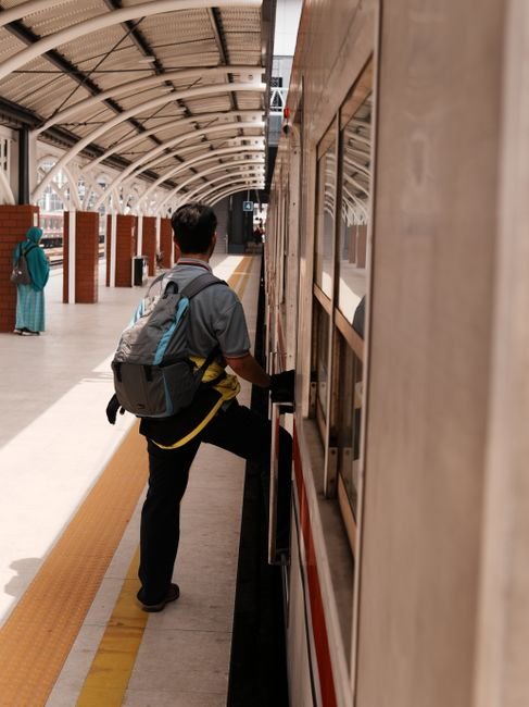 pexels38348706 edc deals commuter with a backpack boarding a train at an urban station