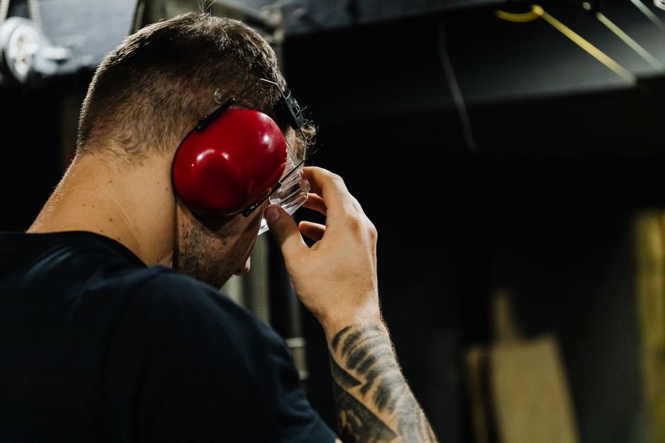 pexels5202420 edc deals shooter adjusting safety glasses and earmuffs at an indoor range