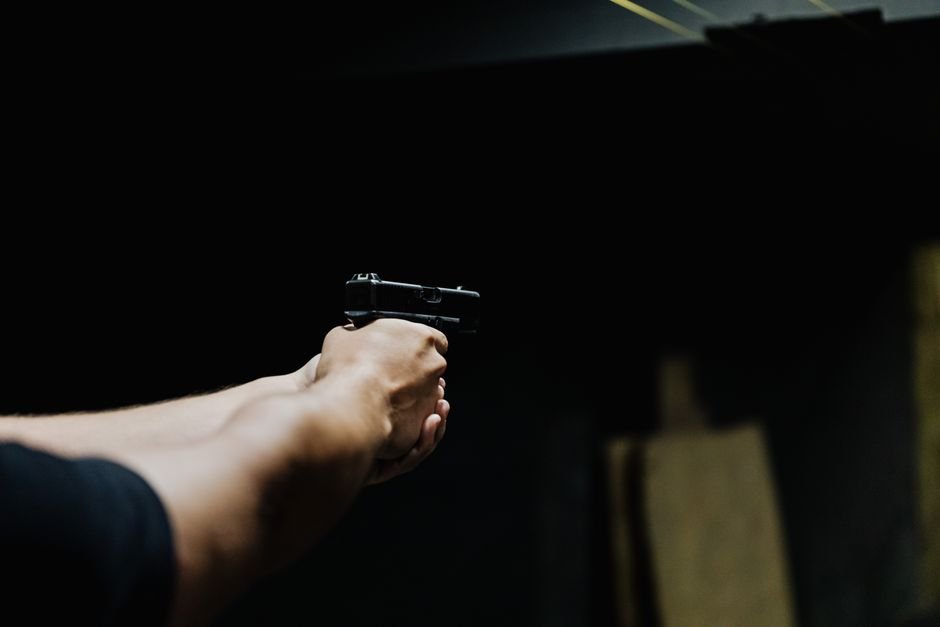 a person aiming a handgun focused on grip and trigger control