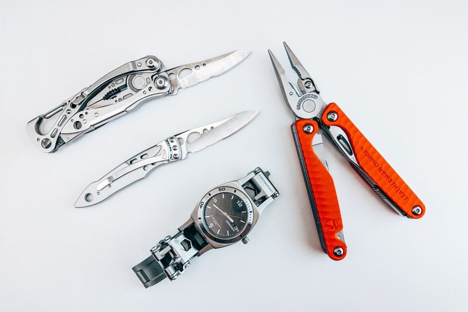 flat lay of multitools and watch on a white background
