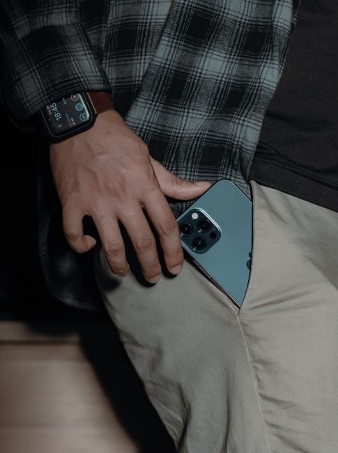 a person putting a smartphone into a pants pocket