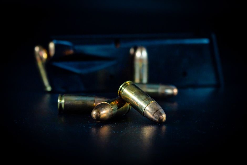 pistol magazine and bullets on a dark surface