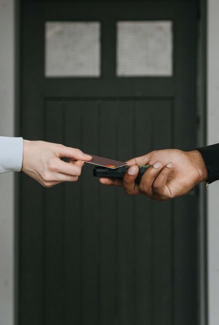 hand tapping a credit card at a contactless payment terminal