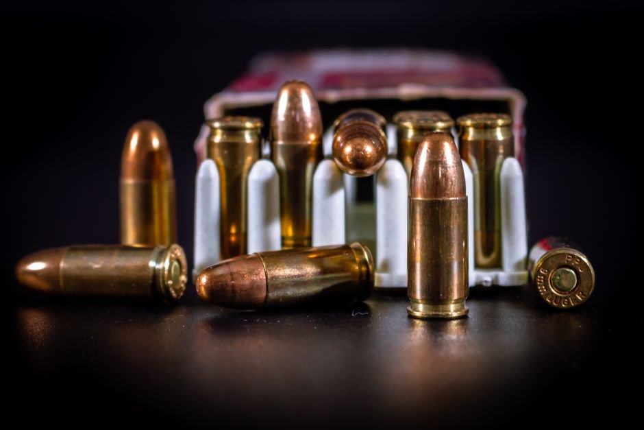 copper 9mm ammunition rounds in a cardboard box