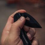 hand gripping an open folding knife edge presented for cutting