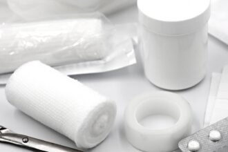 gauze tape safety pins and dressings from a compact first aid kit