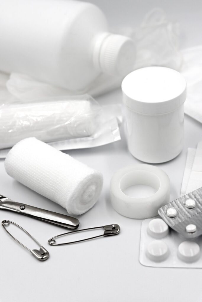 gauze tape safety pins and dressings from a compact first aid kit