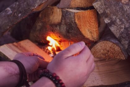 pexelsphoto7148629 edc deals hands feeding tinder into a small fire being coaxed alight