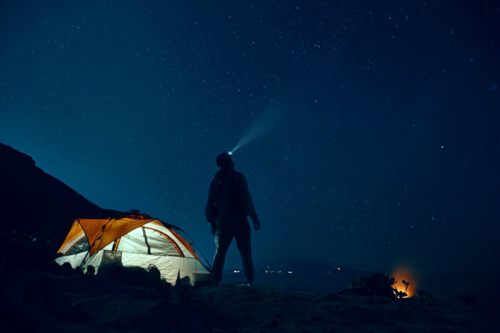 rechargeablevsaaheadlamps edc deals camper wearing a headlamp beside a tent at night