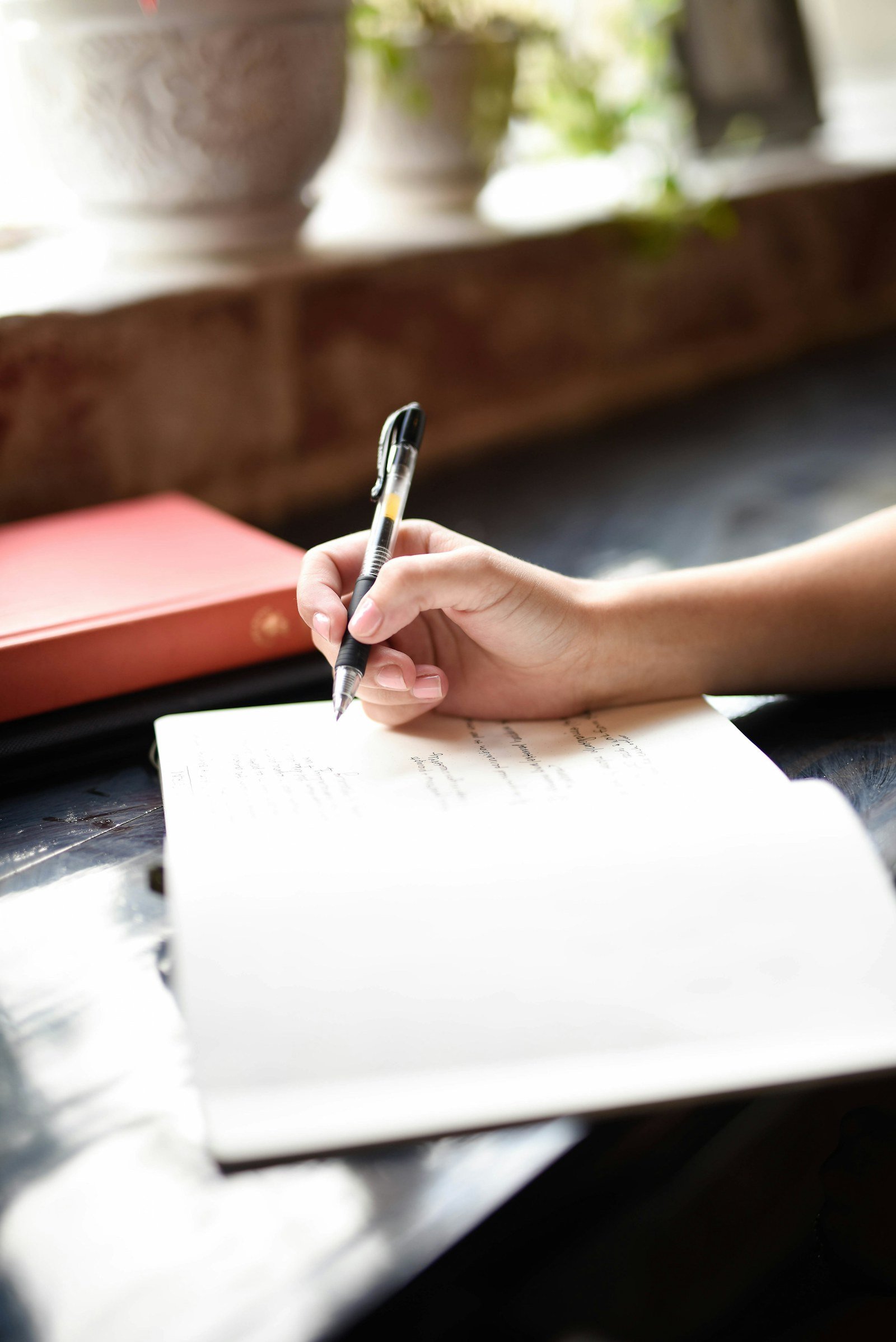 hand holding a slim pen while writing notes testing grip comfort for small hands