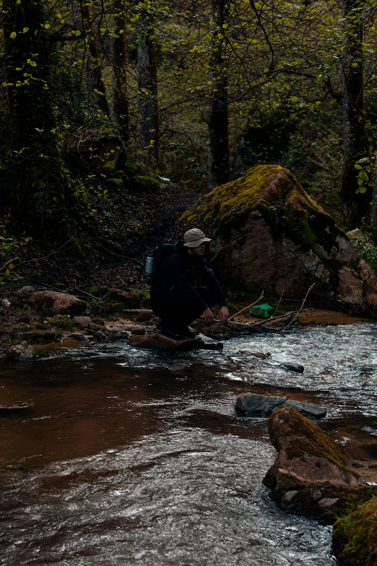 hiker beside a clear forest stream the kind of trail water source that still needs disinfection