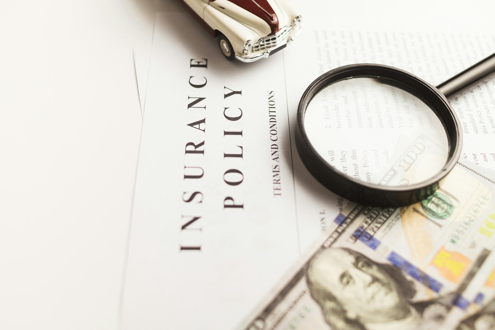 a certificate of motor insurance next to a car key