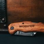 a folding multitool with a wooden handle opened to show its implements
