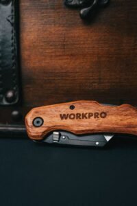 a folding multitool with a wooden handle opened to show its implements