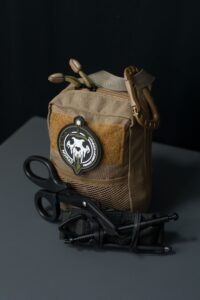 compact tactical pouch with tools laid out beside it